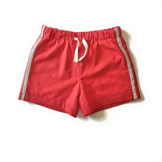 Red shorts with white drawstring and side stripes on a white background